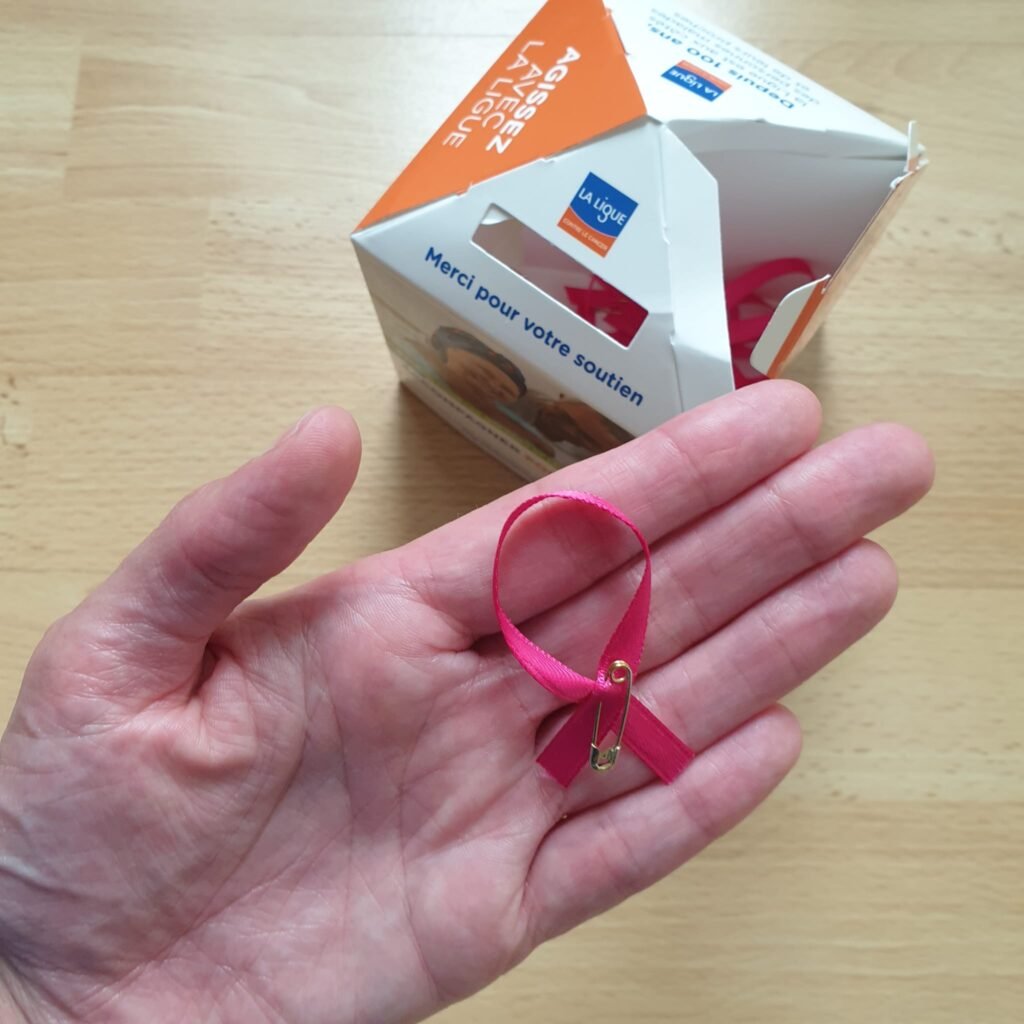Boîte de collecte et épingle ruban rose de la Ligue contre le cancer